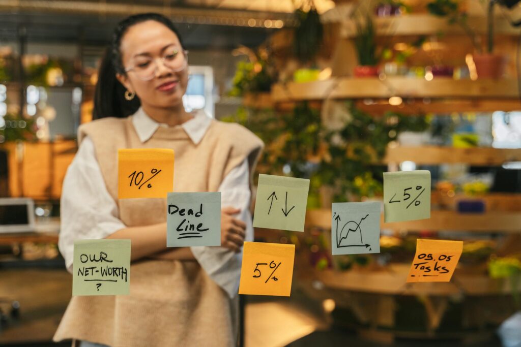 person behind glass with different coloured post it notes