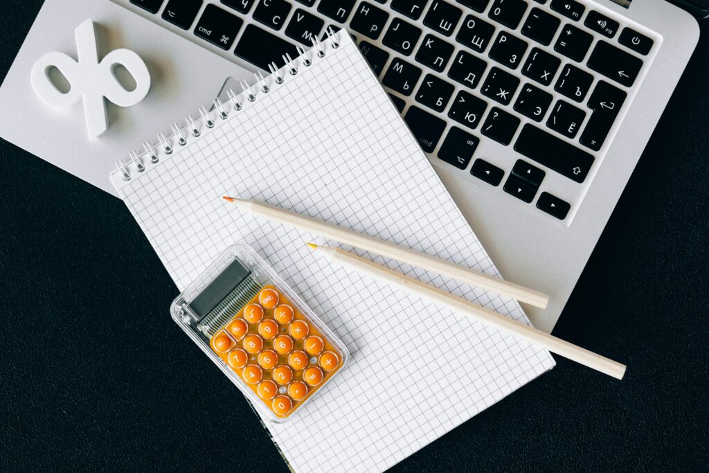 Salary dividends director’s loan - working out which is better. A laptop with a notepad and calculator on