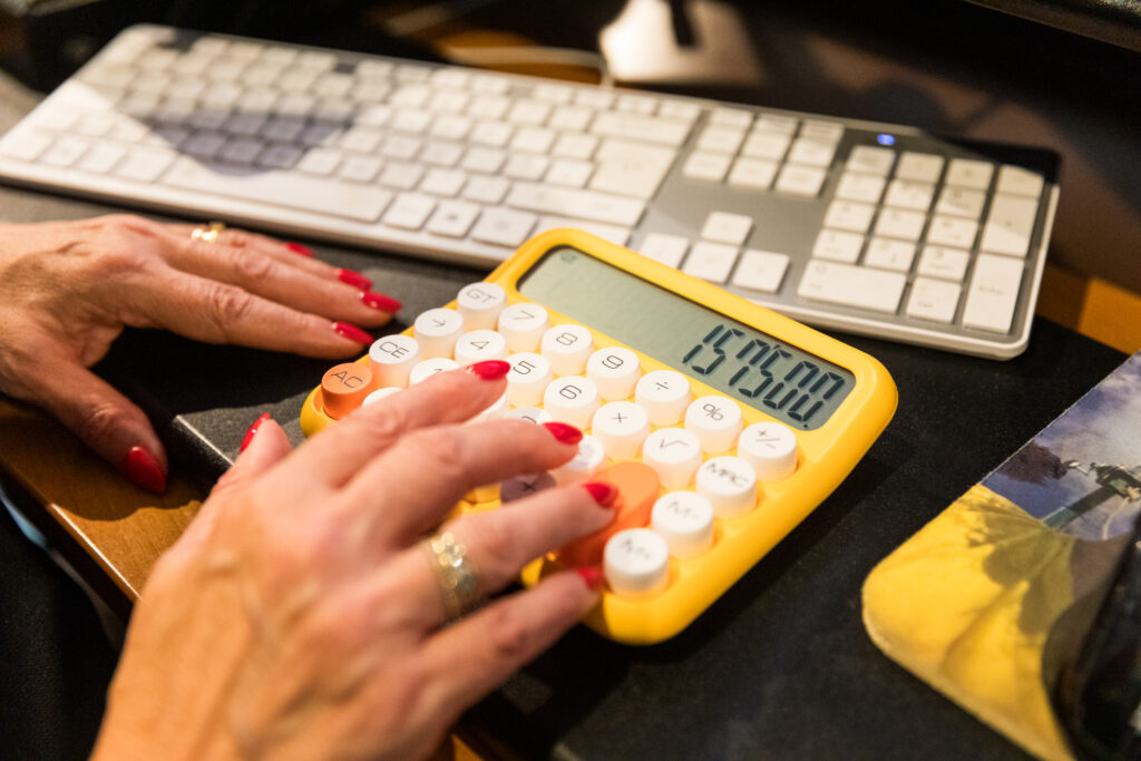 Salary dividends director’s loan - working out which is better. A laptop with a notepad and calculator on